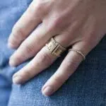 bague multiple en or 18 carats avec des diamants et des pierres précieuses ainsi qu'un anneau solano avec un diamant, porté sur un modèle main