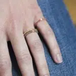 anneaux solano en or 18 carats avec des diamants et pierres précieuses, portés sur un modèle main