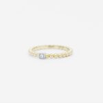 anneau perlé en or jaune 18 carats avec une barrette en or blanc avec un diamant
