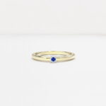 anneau bombé en or jaune 18 carats avec une barrette en or blanc avec une pierre saphir bleu