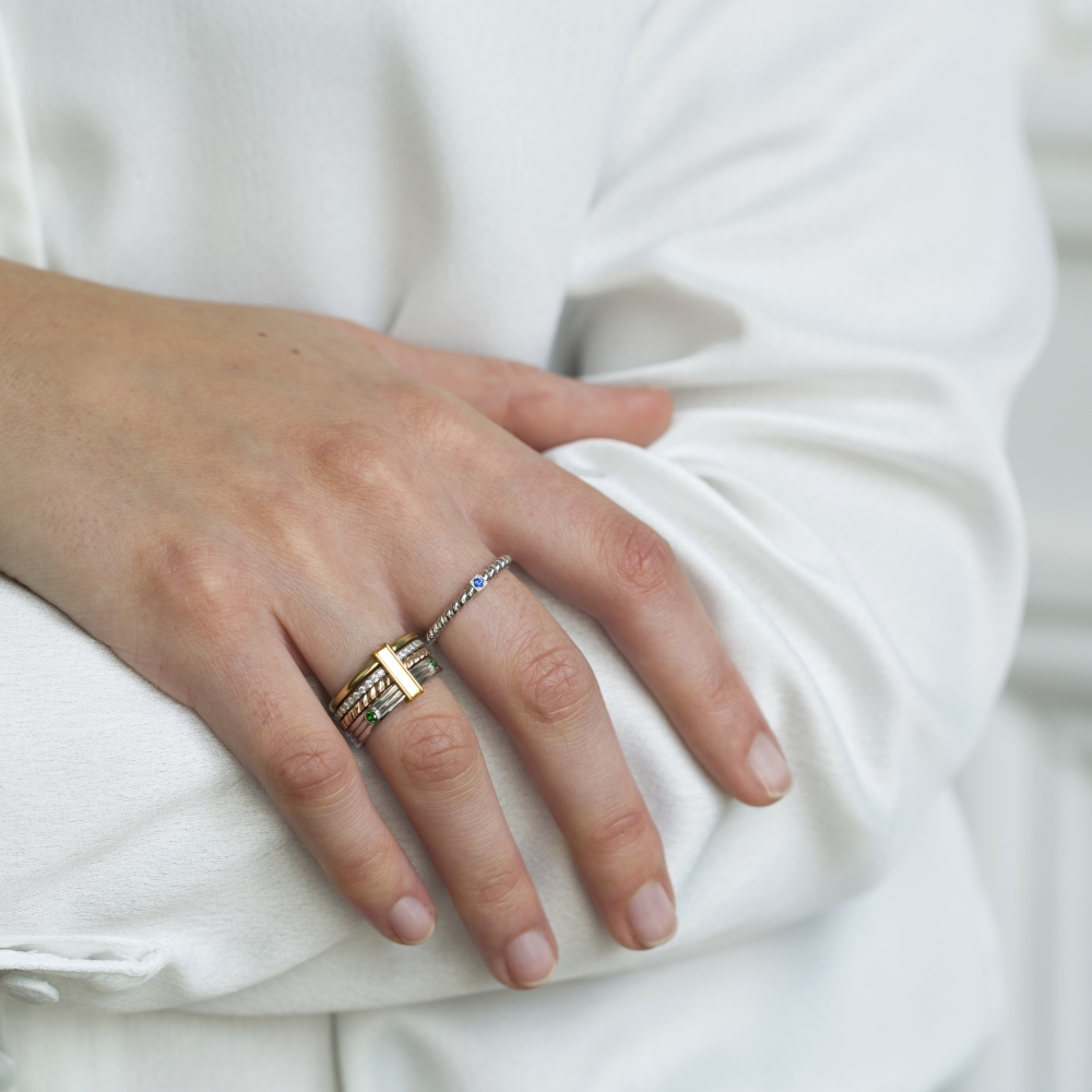bague multiple en or 18 carats avec des diamants et un anneau solano en or blanc, portés sur un modèle main