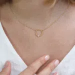 Pendentif en or jaune 18 carats en forme d'anneau perlé et diamant en or blanc, porté sur le cou d'un modèle