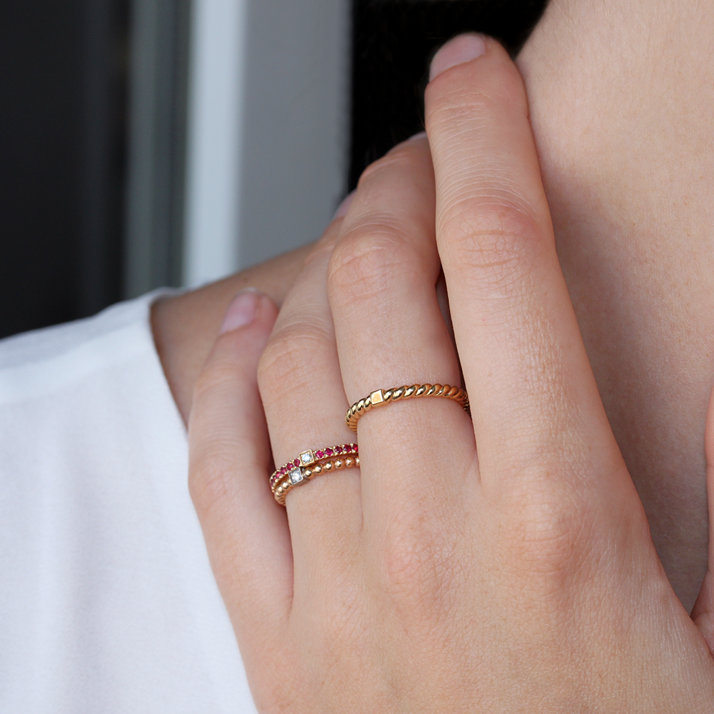 anneaux en or 18 carats avec des diamants et des rubis, portés sur un modèle doigt
