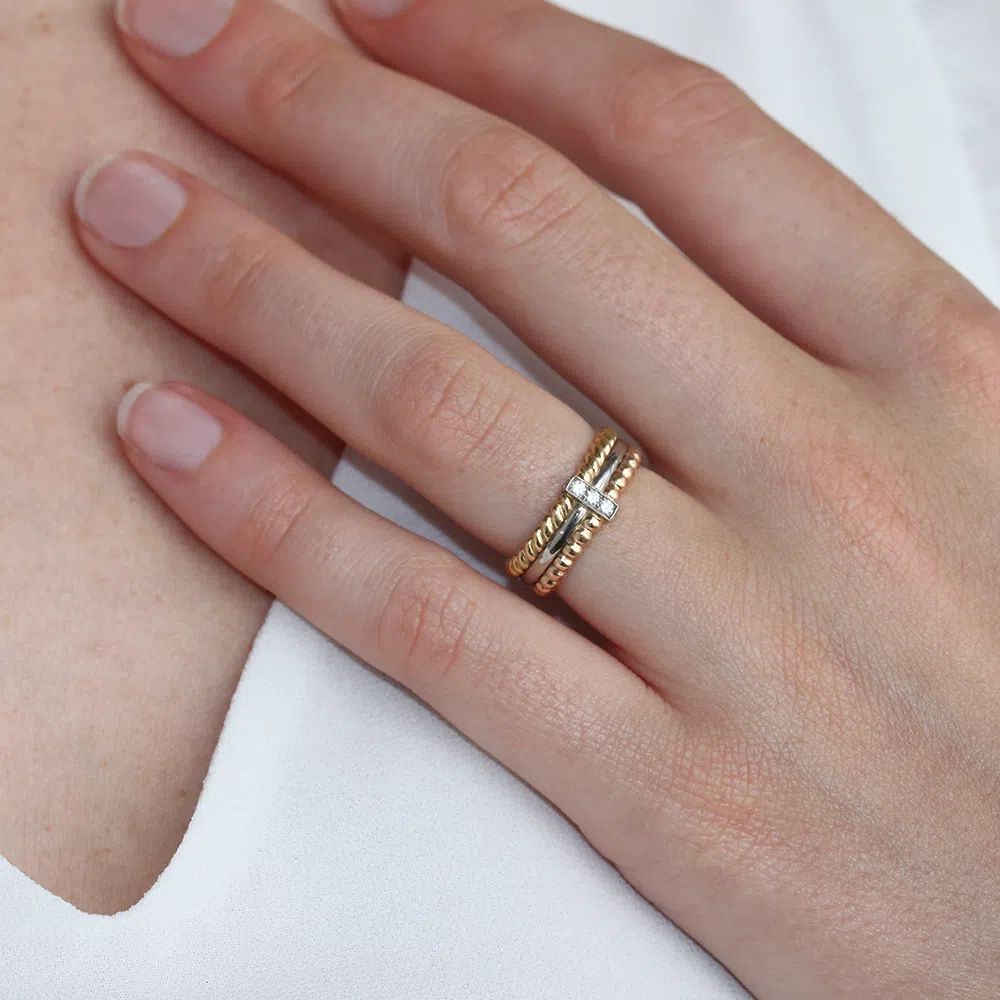 bague multiple en or 18 carats avec une barrette en or blanc avec des diamants, portée sur un modèle doigt