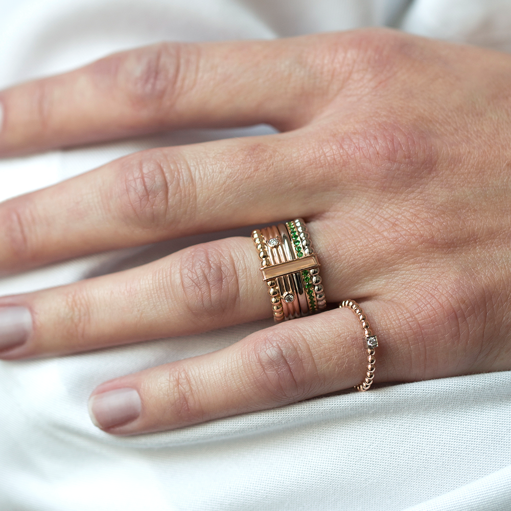 bague et anneau en or 18 carats avec des diamants et des pierres précieuses, portés sur un modèle doigt
