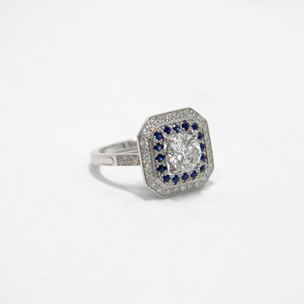 bague arty octogone en or blanc 18 carats alternant avec des diamants et des saphirs bleus, mettant en valeur le diamant central