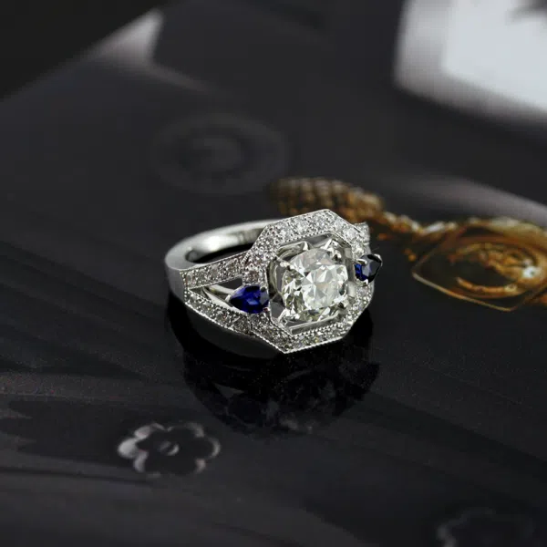 bague arty octogone en or blanc pavée de diamants avec deux saphirs bleus et un diamant central