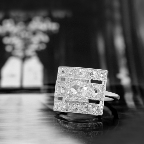Bague art déco carré en or blanc 18 carats sertie d'un diamant en pierre de centre et de diamants entourant cette pierre.
