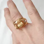Bague en or jaune 18 carats serti de diamants en croisillons en les 2 anneaux ainsi qu'une citrine en pierre de centre portée sur une main